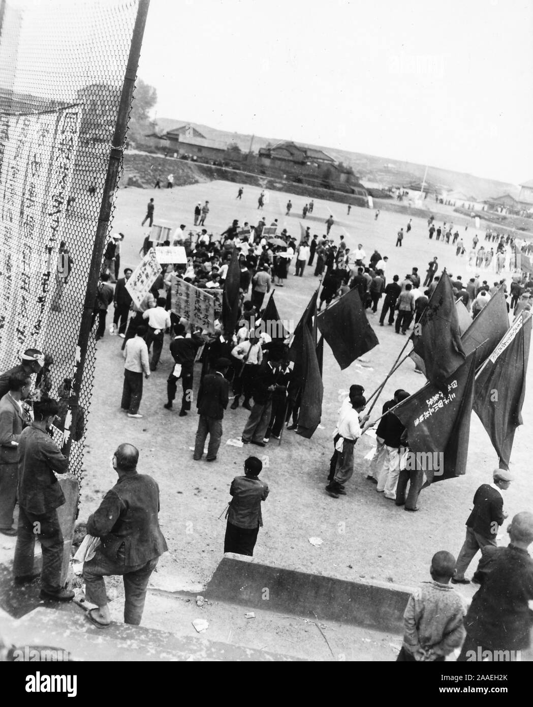 D'un grand angle de vue sur une foule de manifestants, certains portant des drapeaux et des pancartes, laissant un terrain de jeu urbain à la suite d'une manifestation syndicale du travail sur l'image, la Préfecture de Fukuoka, Japon, 1950. () Banque D'Images