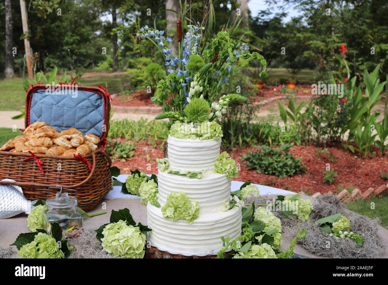 Gâteau de mariage en plein air avec des accents floraux. Banque D'Images