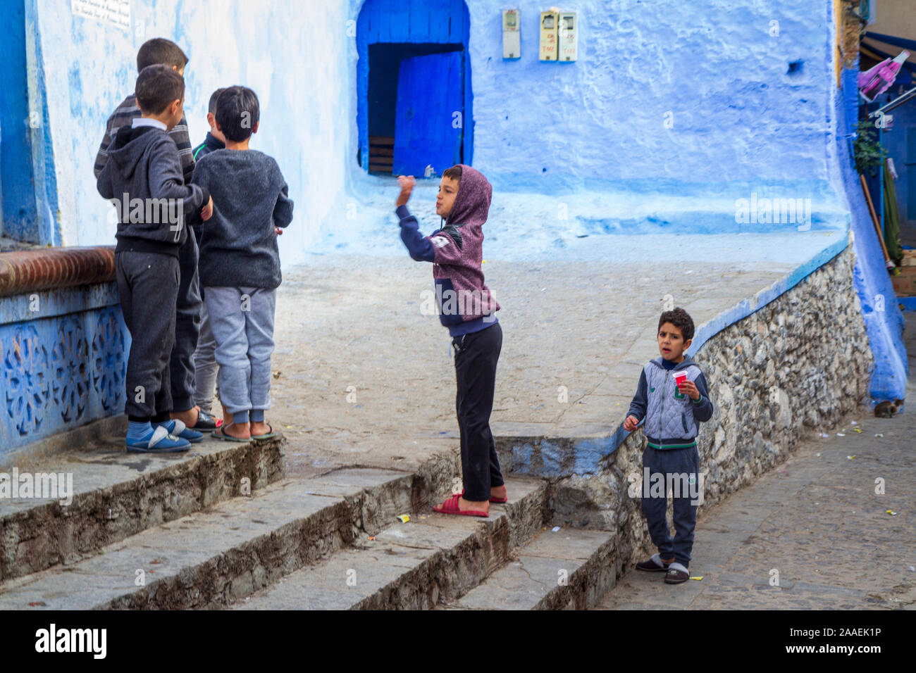 Un groupe d'enfants jouant dans l'une des routes de Chefchauen la 'Blue Pearl' dans les montagnes du Maroc dans une journée ensoleillée au cours de la saison d'automne. Banque D'Images