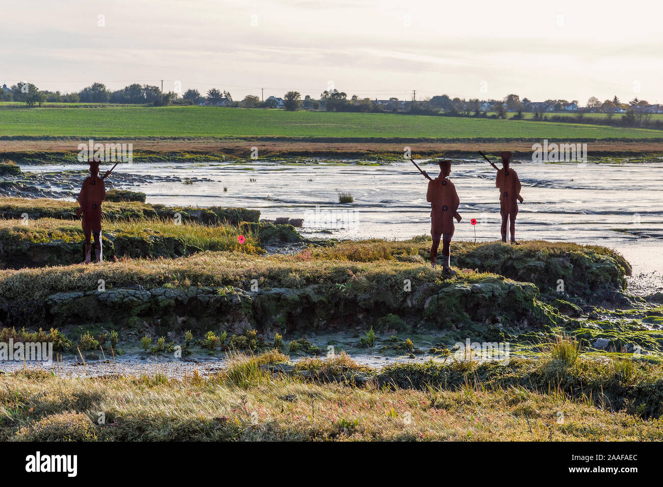 Silhouettes de metal WW1 soldats regarde l'ensemble du paysage. Coquelicots à leurs pieds. L'occasion d'un hommage aux hommes qui ont perdu la vie dans la PREMIÈRE GUERRE MONDIALE. Banque D'Images