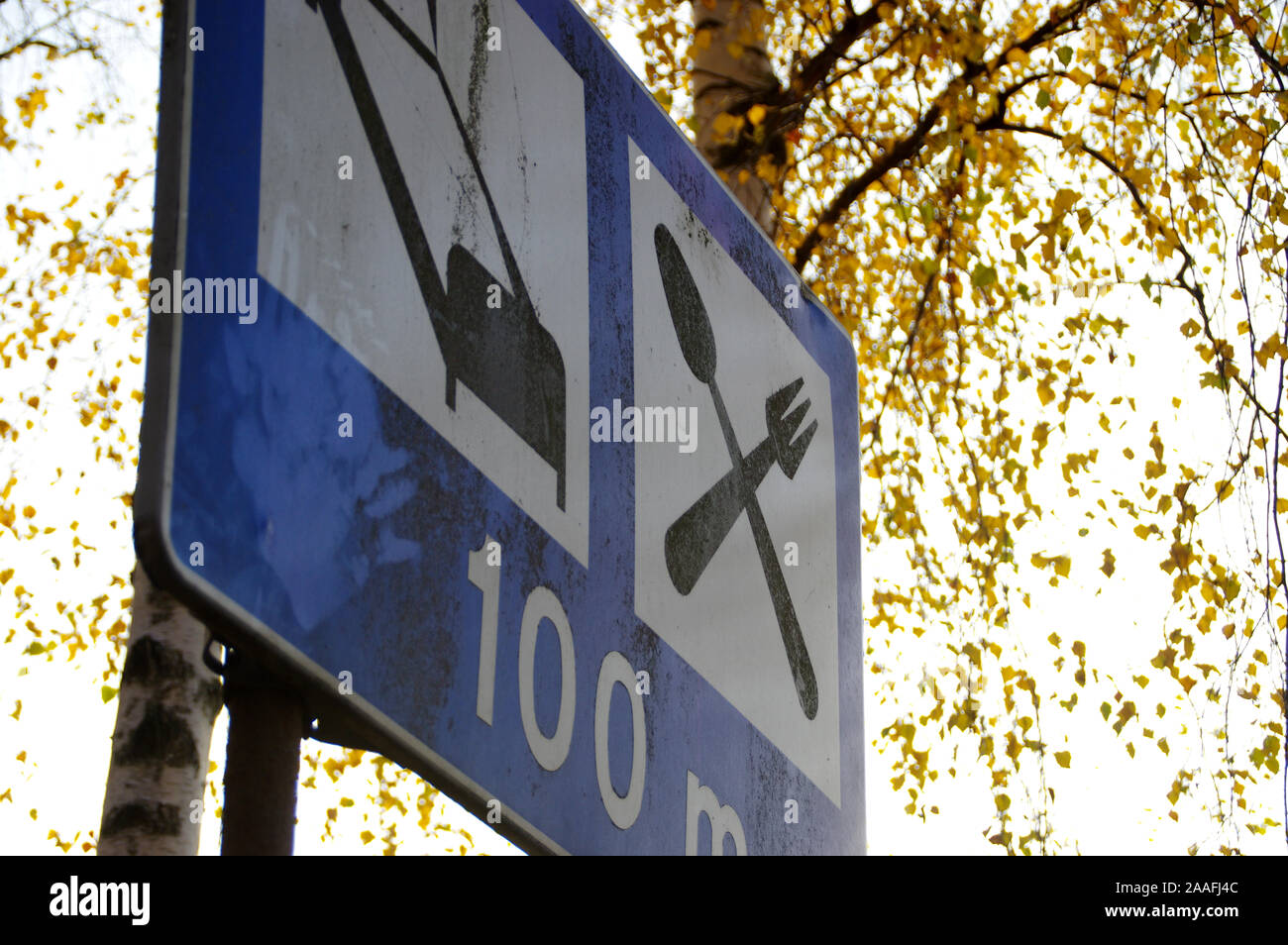 Signe routière Hôtel et restaurant sur un fond d'arbres. Vieux, panneau endommagé par la route. Banque D'Images