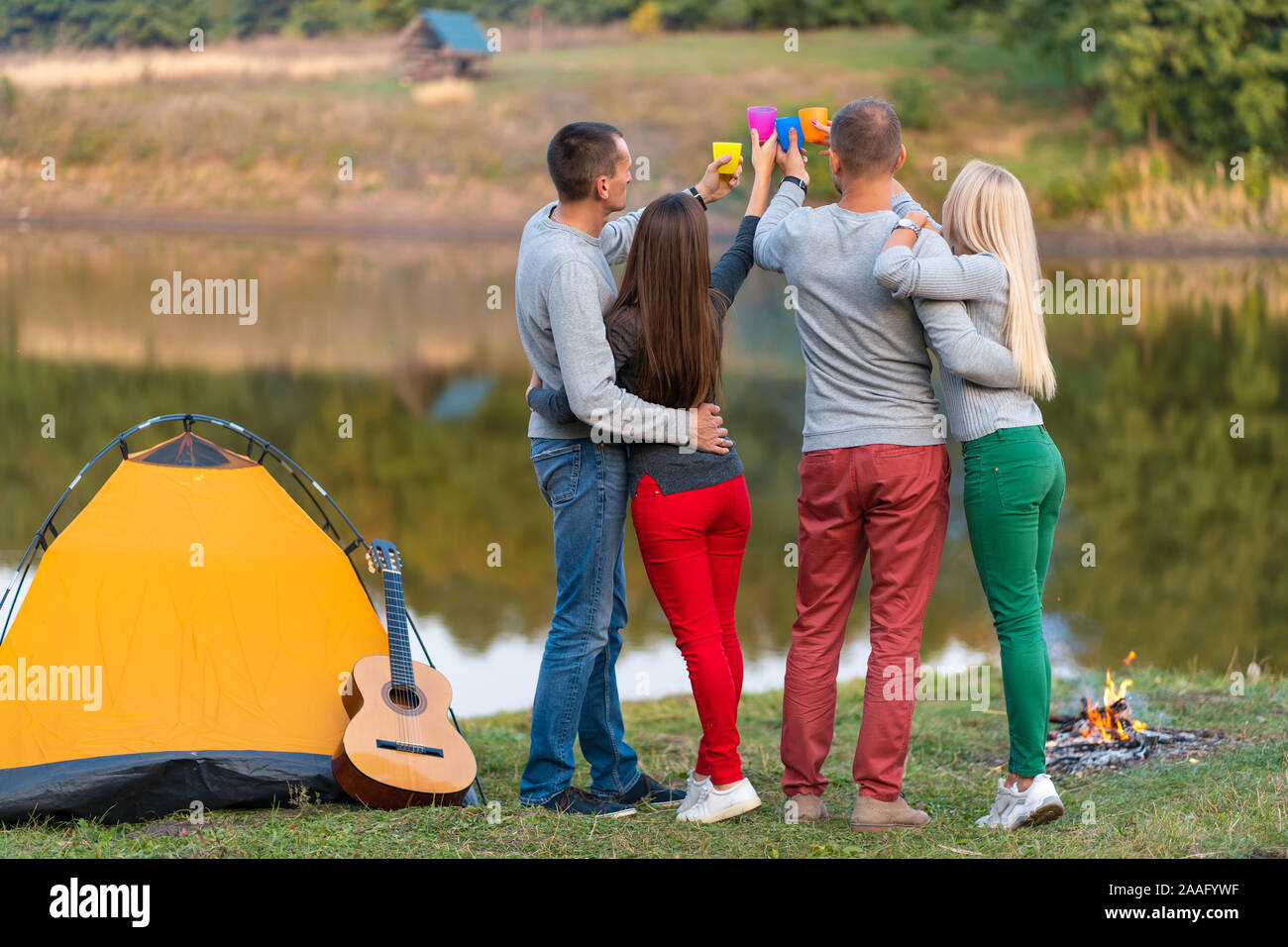 Pique-nique avec des amis au lac près de la tente de camping. Les amis de l'entreprise avoir pique-nique Randonnée nature background. Les randonneurs se détendre pendant le temps de boire. Summer picn Banque D'Images