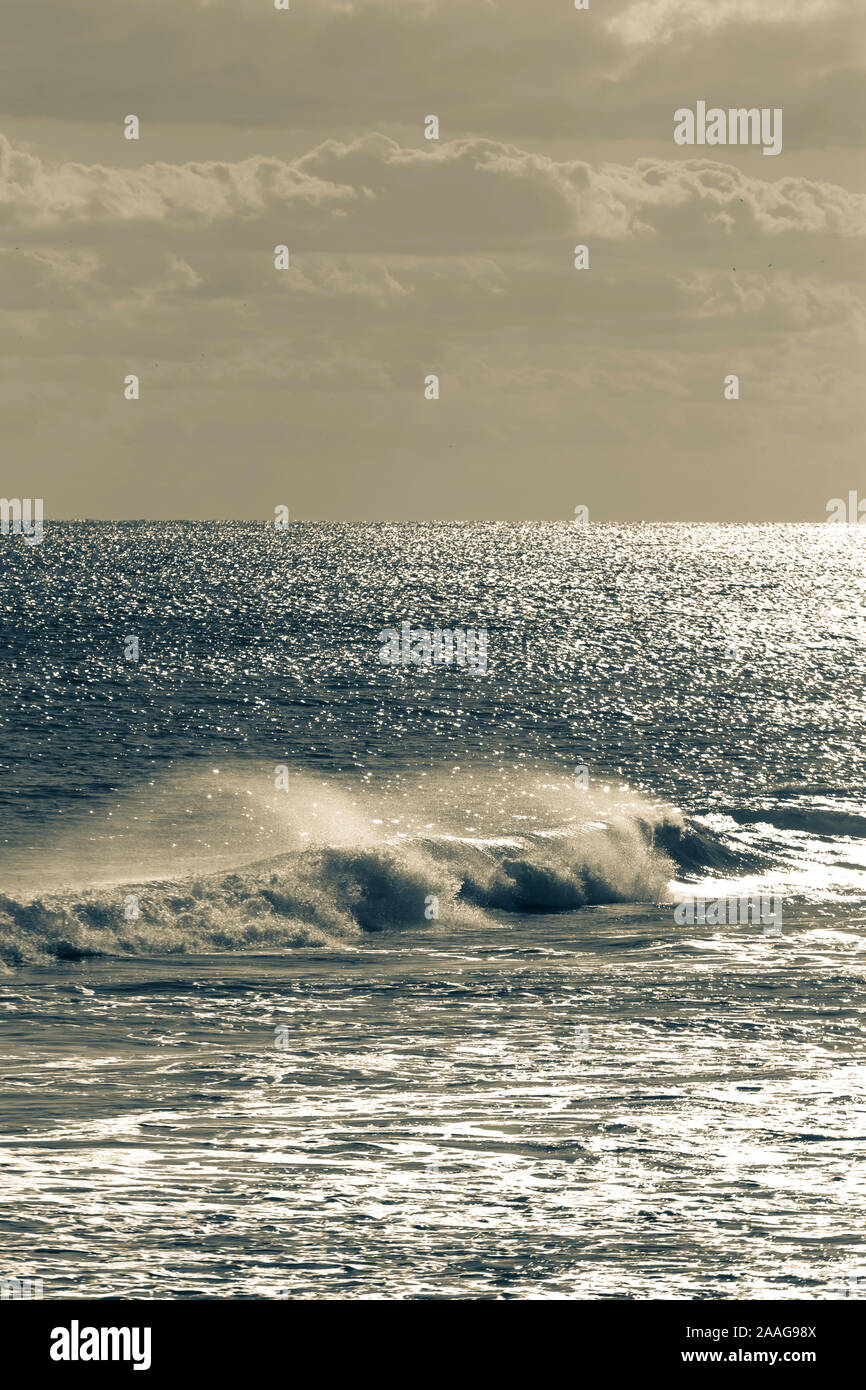 Vue stylisé gris et bleu océan vagues de s'écraser et rouler sur un jour lumineux Banque D'Images