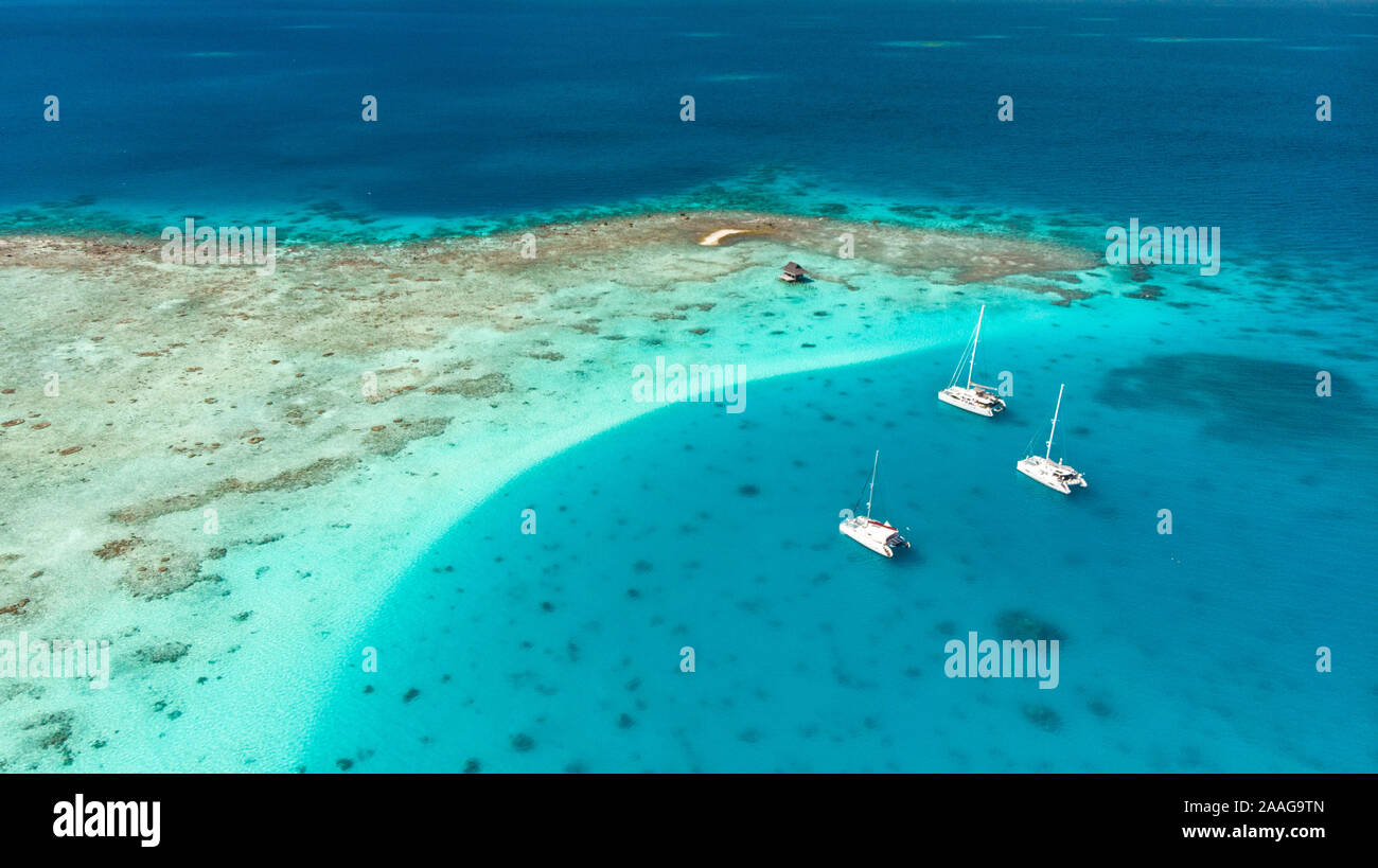 Yacht à voile plusieur bateaux dans l'archipel des Tuamotu - atoll de Tikehau plage de sable rose du désert Banque D'Images