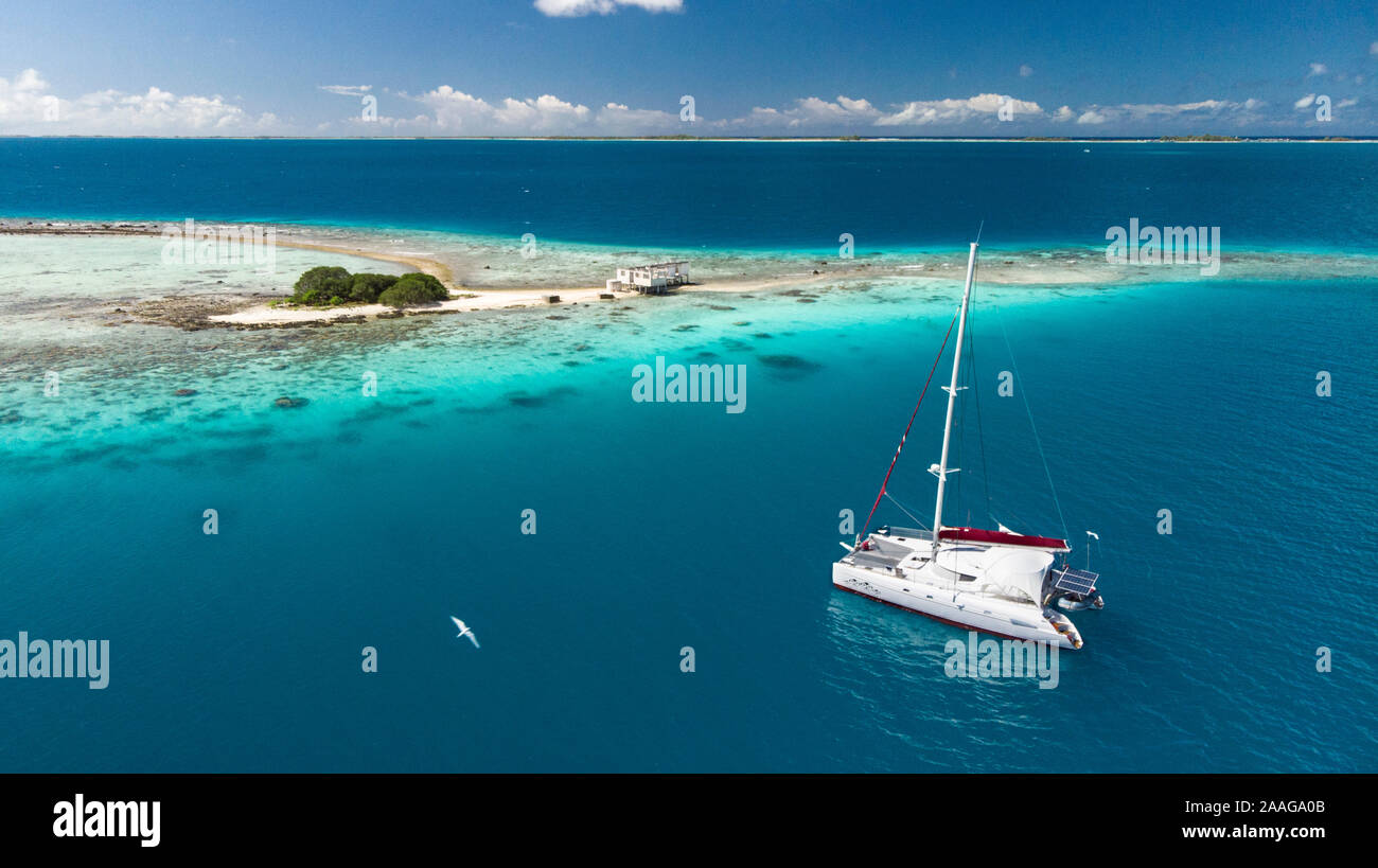 Yacht à voile plusieur bateaux dans l'archipel des Tuamotu - atoll de Tikehau plage de sable rose du désert Banque D'Images