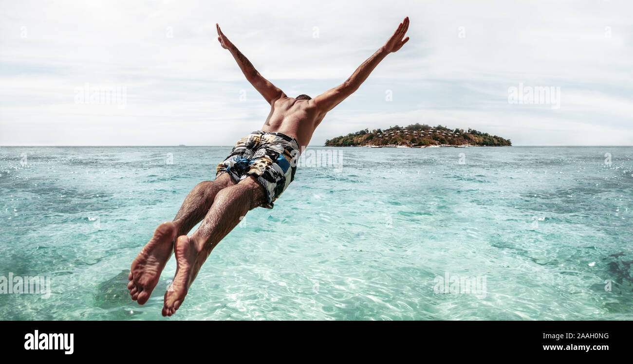 Look sportif homme passe comme athlète avec les bras levés dans l'eau turquoise Banque D'Images