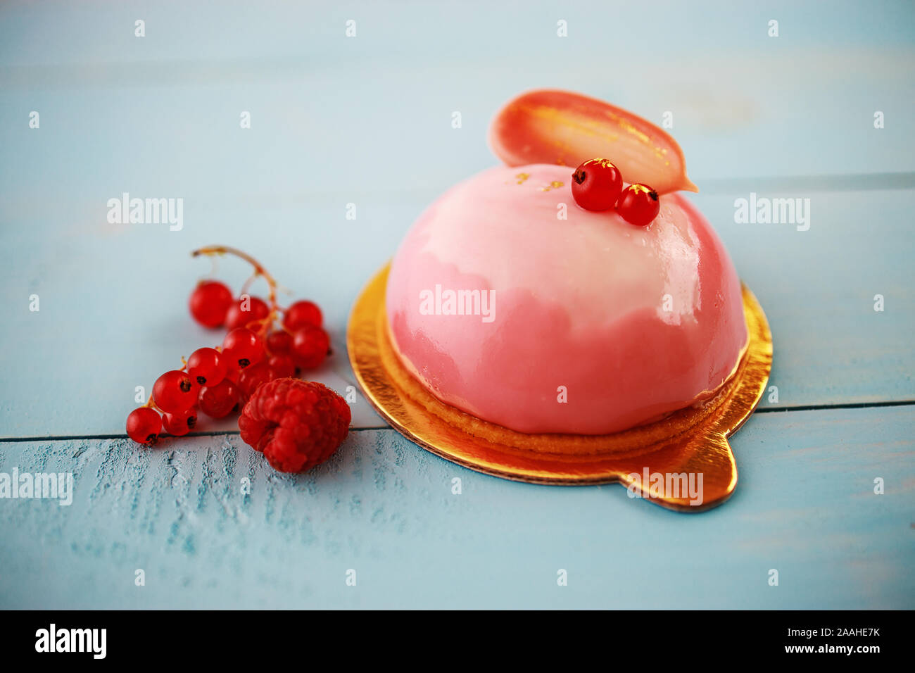 Avec la purée de fraises gâteau Mousse, crème et fruits sur fond bleu en bois Banque D'Images