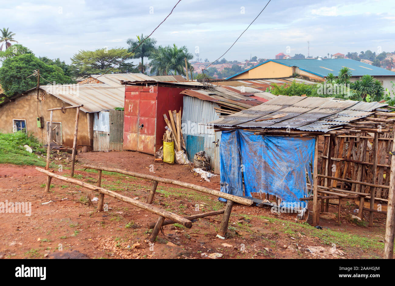 Vue de la route de bidonville du tiers monde les bâtiments communautaires dans la périphérie de Kampala, Ouganda, Région centrale avec toit en tôle ondulée shacks Banque D'Images