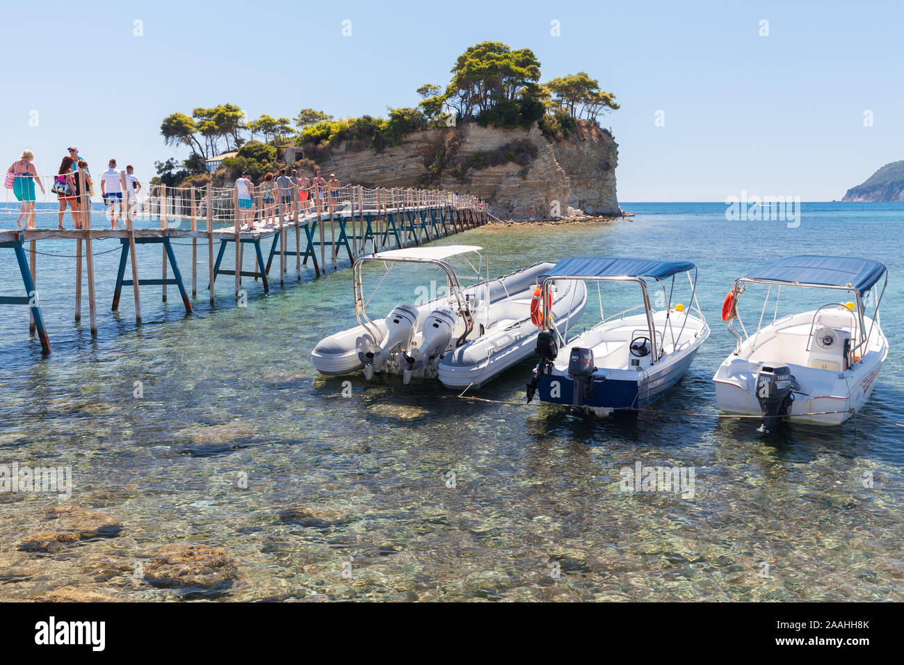 Zakynthos, Grèce - le 17 août 2016 : les touristes à pied sur le pont d'Agios Sostis. Bateaux à moteur de plaisance sont amarrés près de l'île d'été ensoleillé à Cameo da Banque D'Images