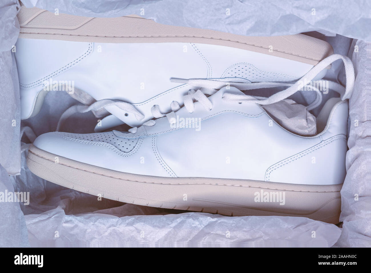 Nouvelles sneakers blanc occasionnels dans une boite à chaussure, concept photo, achats en ligne, thème de fond, nouvelles chaussures couverts dans du papier d'emballage Banque D'Images Nouvelles sneakers blanc occasionnels dans une boite à chaussure, concept photo, achats en ligne, thème de fond, nouvelles chaussures couverts dans du papier d'emballage Banque D'Images