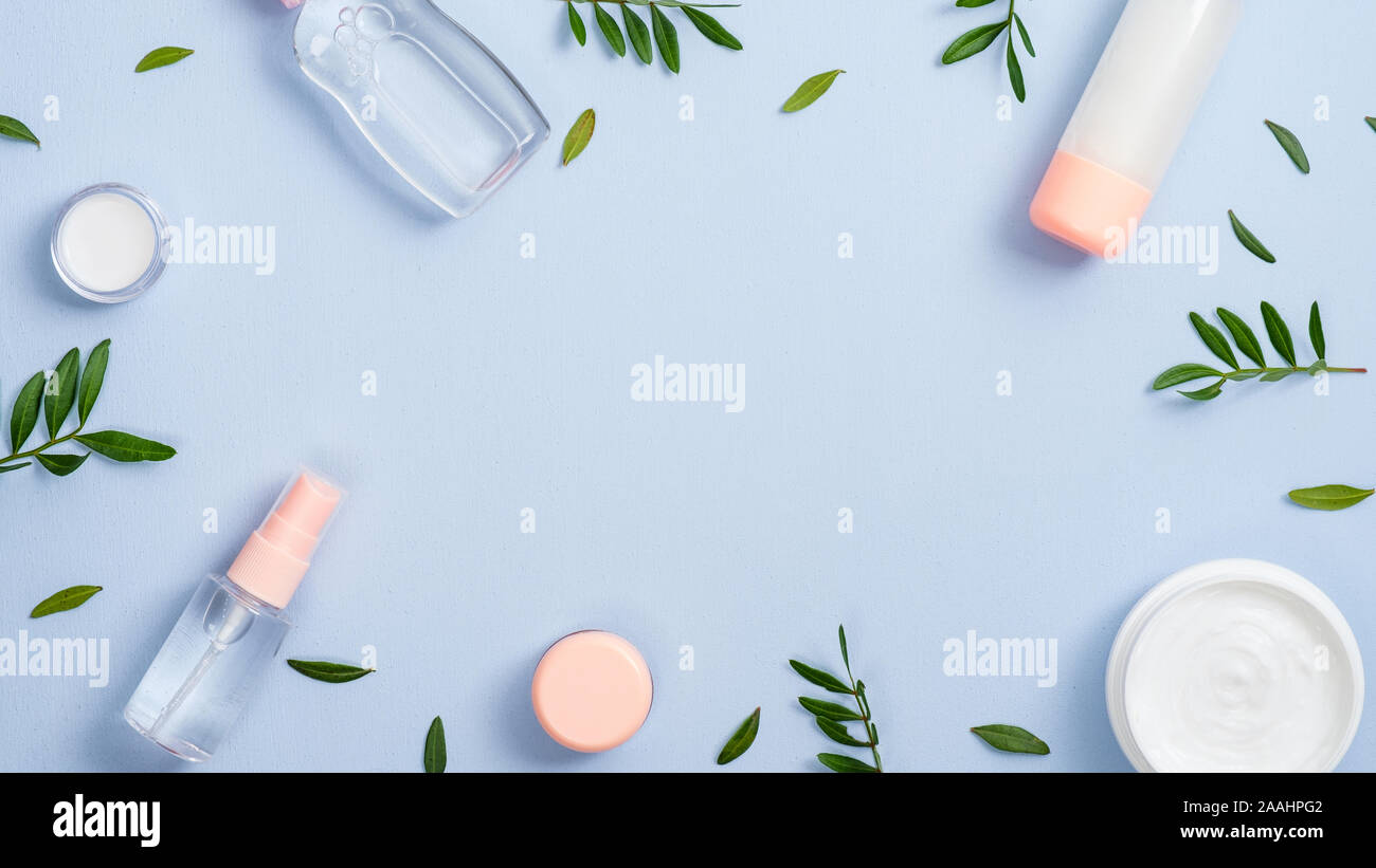 Cadre du visage bio produits cosmétiques et feuilles vertes sur fond bleu pastel. Produit de beauté naturel concept. Télévision minimal style laïcs compositi Banque D'Images