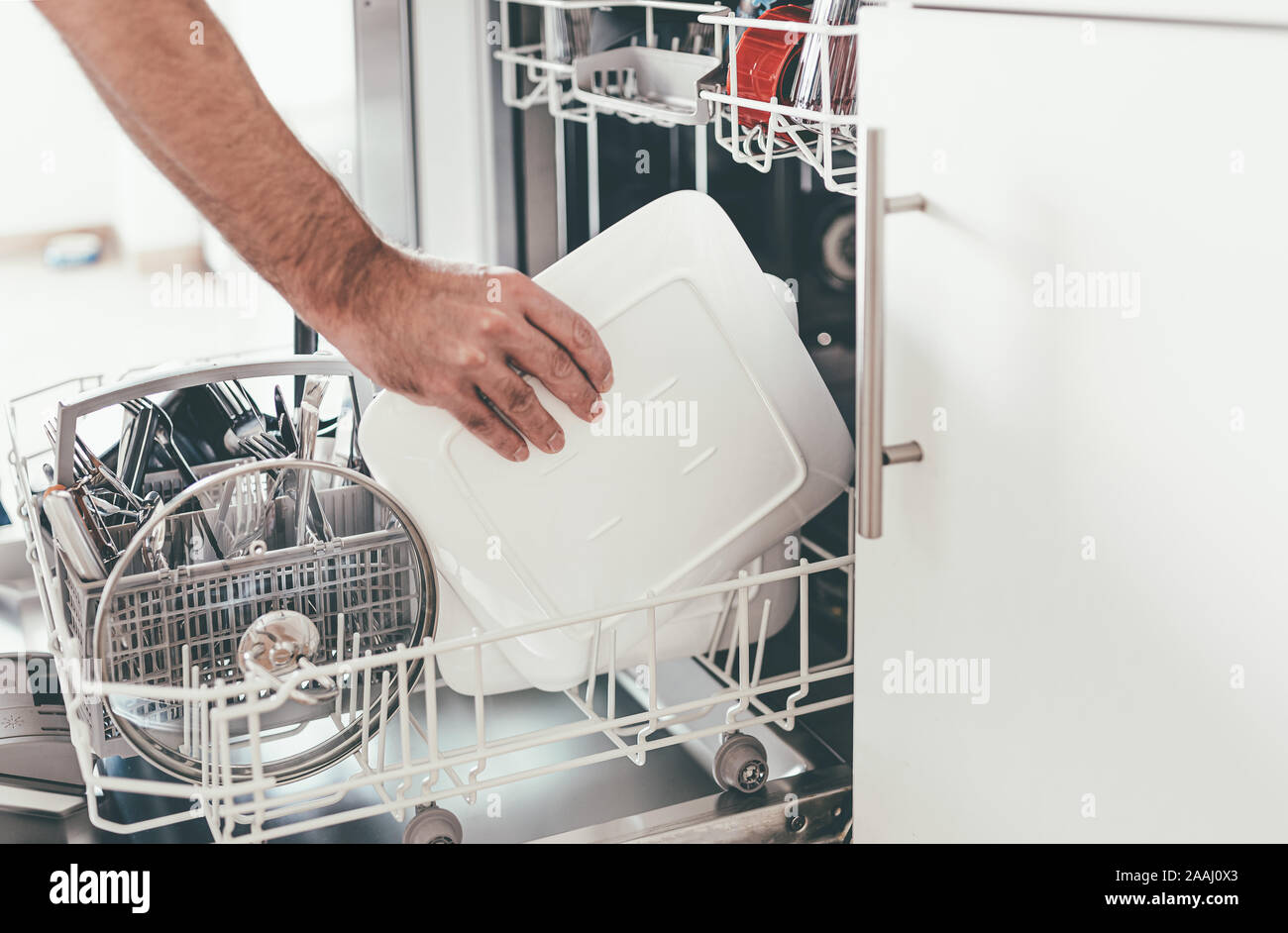 Close-up de vider personne ou le chargement d'un lave-vaisselle dans la cuisine Banque D'Images