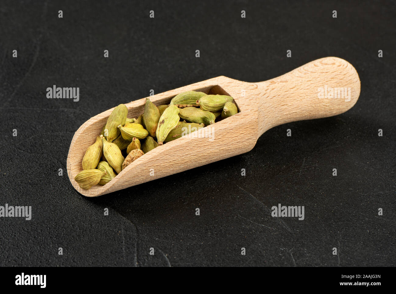 Cardamome verte en scoop sur fond sombre Banque D'Images