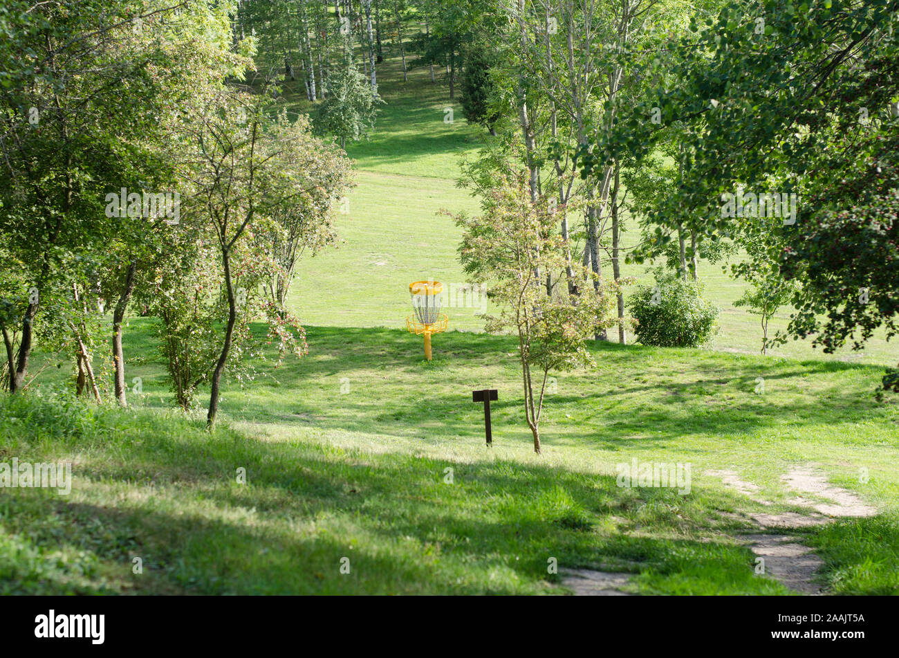 Vue d'un panier sur un parcours de discgolf sous le soleil d'été. Banque D'Images Vue d'un panier sur un parcours de discgolf sous le soleil d'été. Banque D'Images