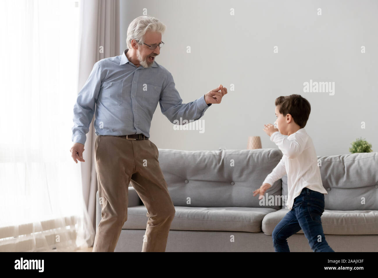 Heureux grand-père et petit-fils de danse à la musique ensemble Banque D'Images