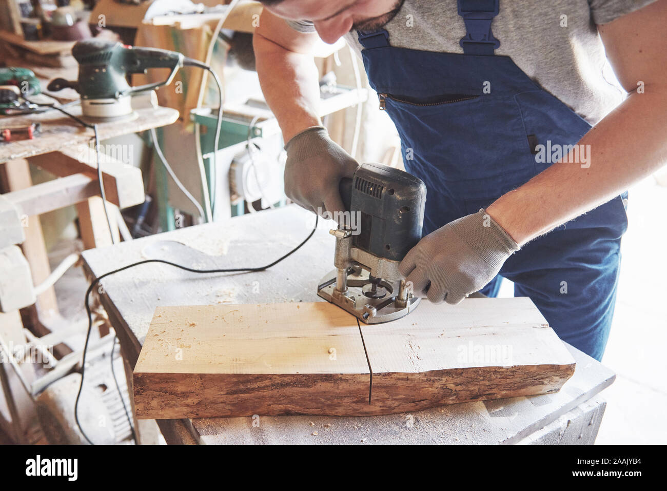 Portrait d'un charpentier de vêtements de travail dans l'atelier du menuisier. Banque D'Images