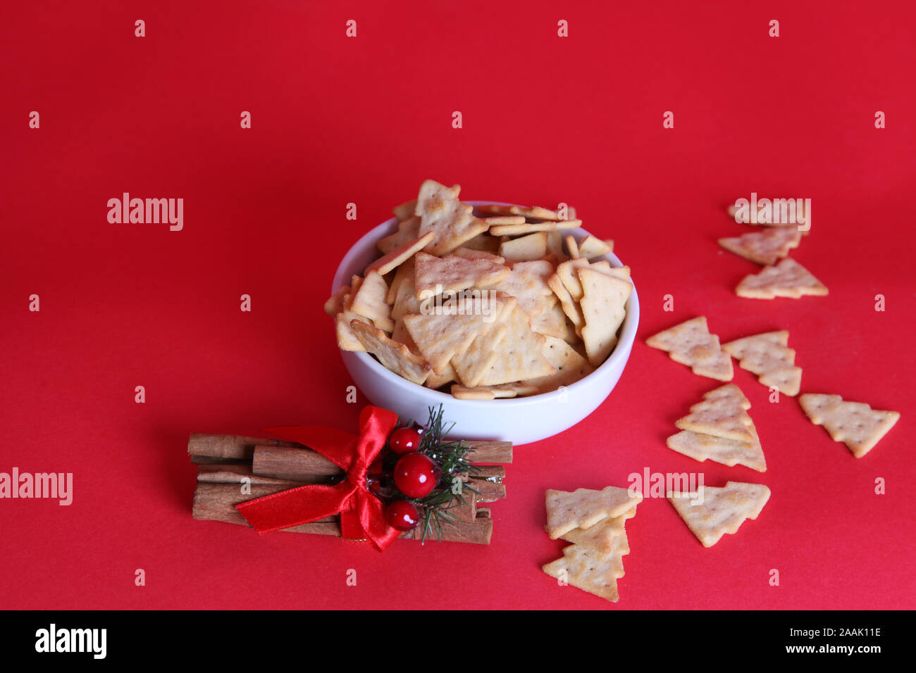 Jacobs Treesalls 2019, chips/craquelins en forme d'arbre de Noël, à base de cheesalls, dans un bol avec un peu éparpillés sur fond rouge avec espace de copie Banque D'Images