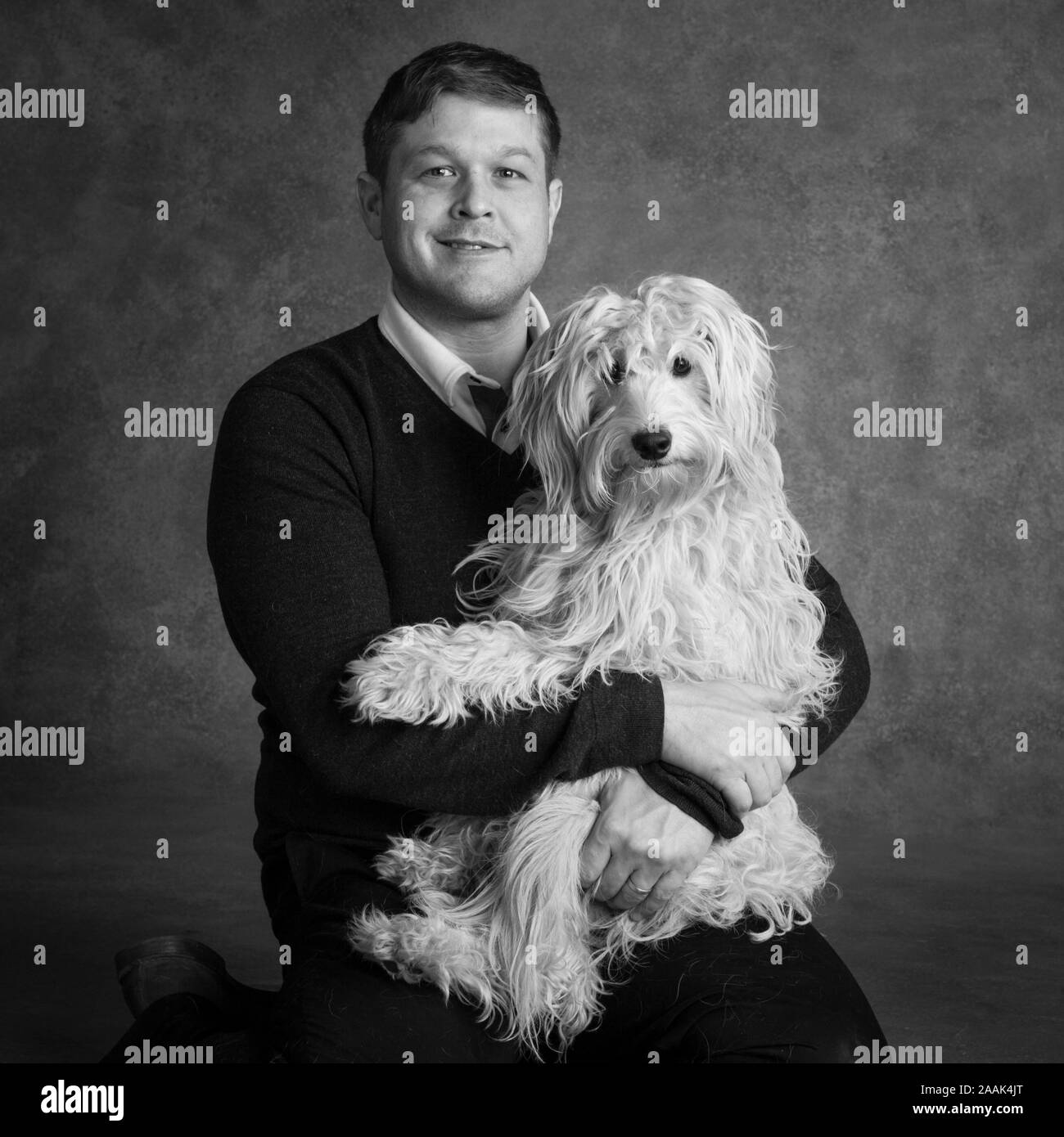 Studio portrait of man avec Mini Golden Doodle Banque D'Images