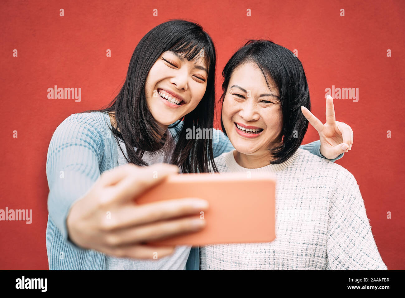 Mère et fille asiatique photo prise avec selfies mobile smartphone outdoor - Happy Chinese family having fun avec de nouvelles applications de la technologie tendances Banque D'Images