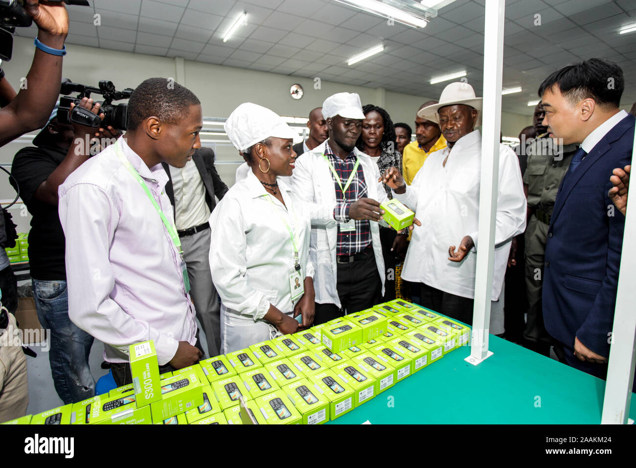 (191122) -- MUKONO (Ouganda), du 22 novembre 2019 (Xinhua) -- Le Président ougandais Yoweri Museveni (2e R, à l'avant) se penche sur les produits finis à l'usine de téléphone de l'Engo Holdings Group Limited à Namanve Industrial Park à Mukono, Ouganda, le 22 novembre, 2019. Société d'électronique chinois, les ONGE Holdings Group Limited, le vendredi a ouvert une usine de 5 millions de dollars américains en Ouganda, qui fabriquera des téléphones cellulaires et les ordinateurs portables. (Photo par Hajarah Nalwadda/Xinhua) Banque D'Images