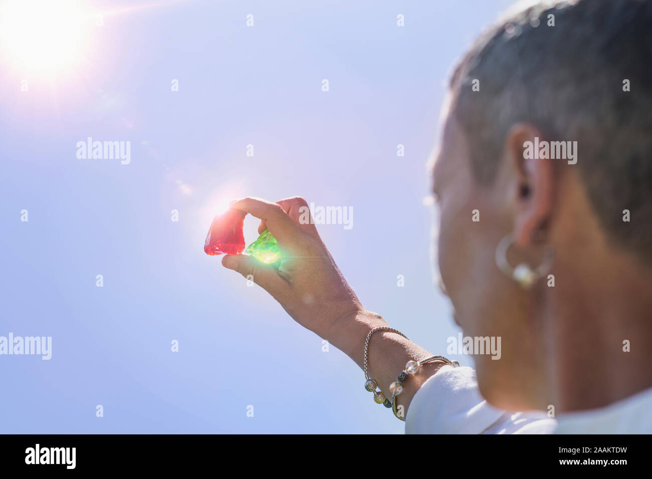 Crystal femelle thérapeute guérison hand holding red et vert émeraude cristaux andara. Nettoyage ethnique et de charge des cristaux. Banque D'Images