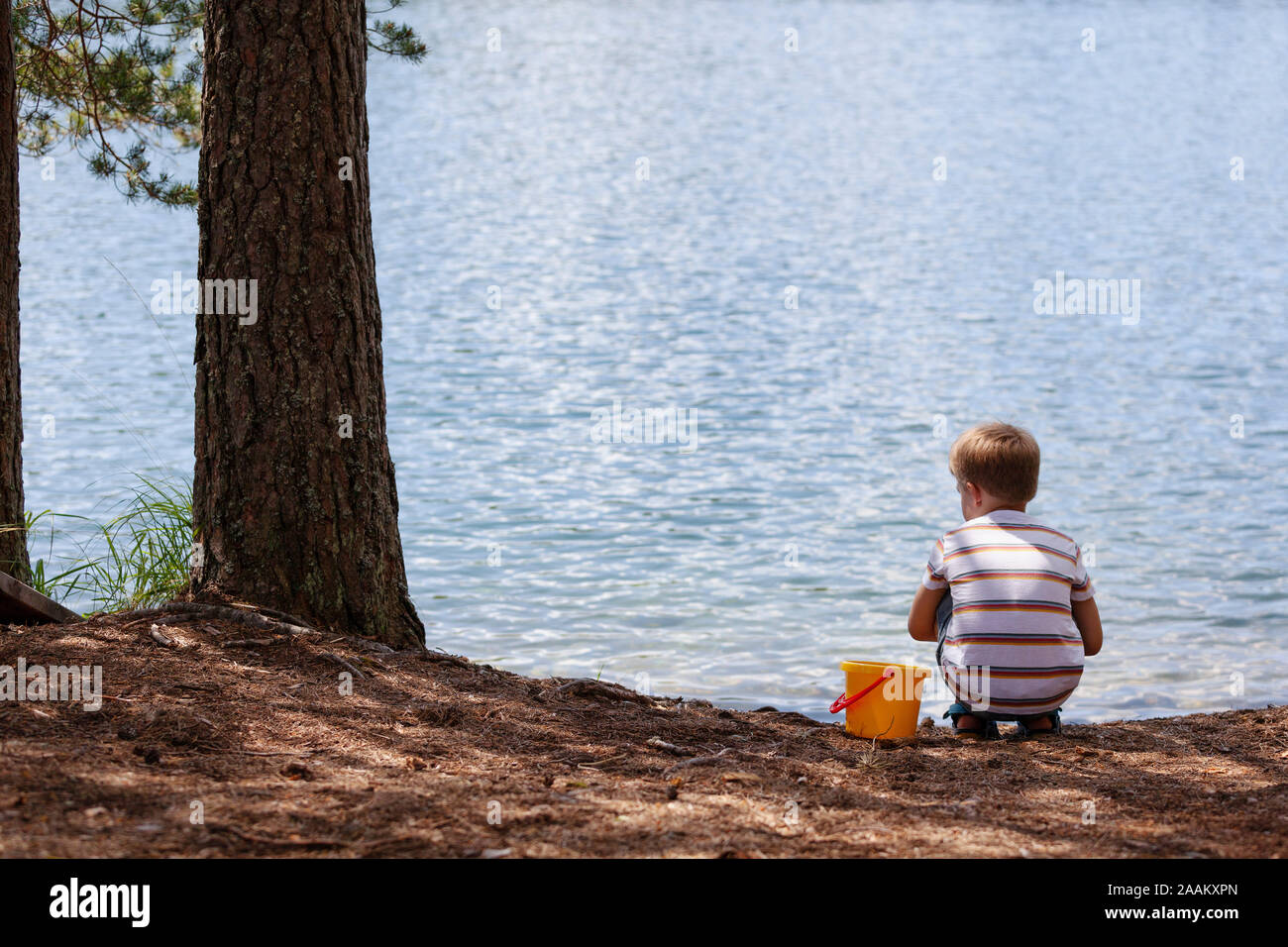 Garçon jouant près du lac Banque D'Images