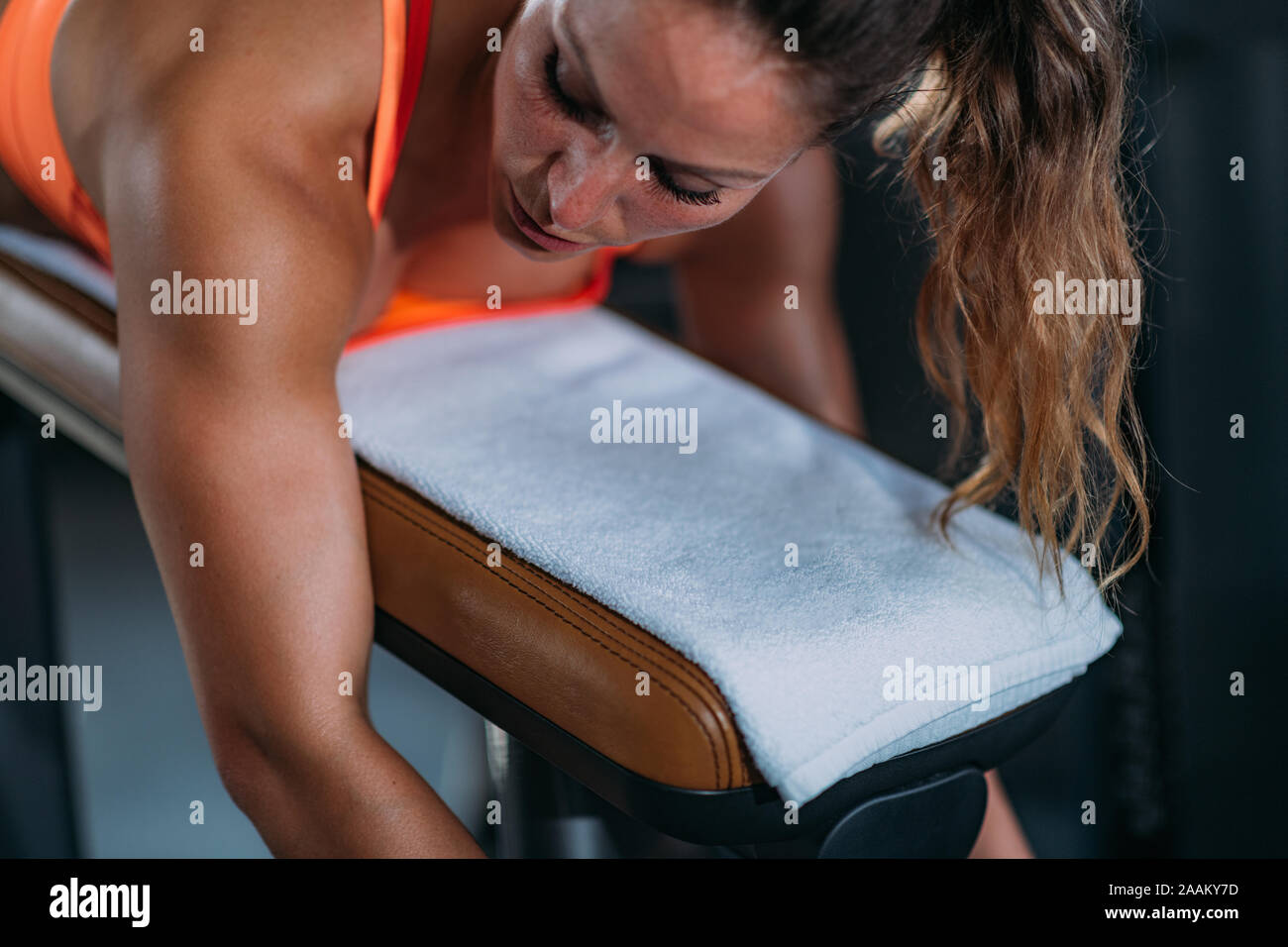 Athlète féminin de l'exercice à lying leg curl banc dans le sport. Banque D'Images