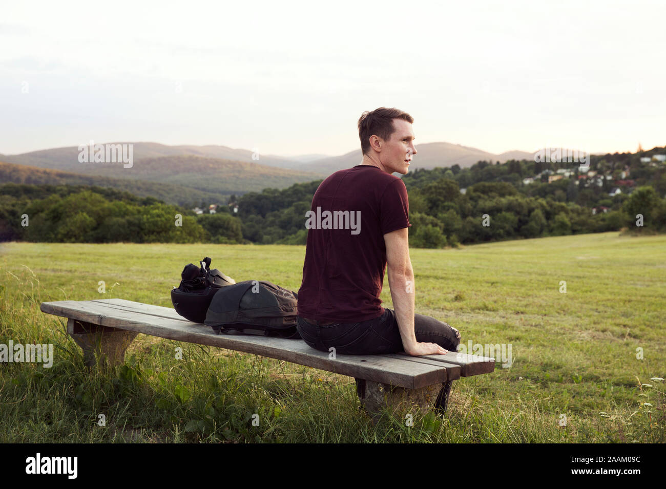 Homme assis sur banc avec vue sur collines, Wilhelminenberg, Vienne, Autriche Banque D'Images