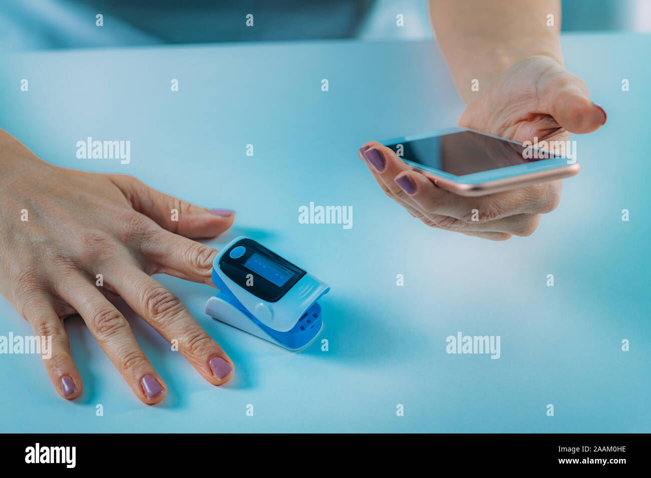 Femme à l'aide d'un sphygmo-oxymètre et smart phone, la mesure de la  saturation en oxygène Photo Stock - Alamy