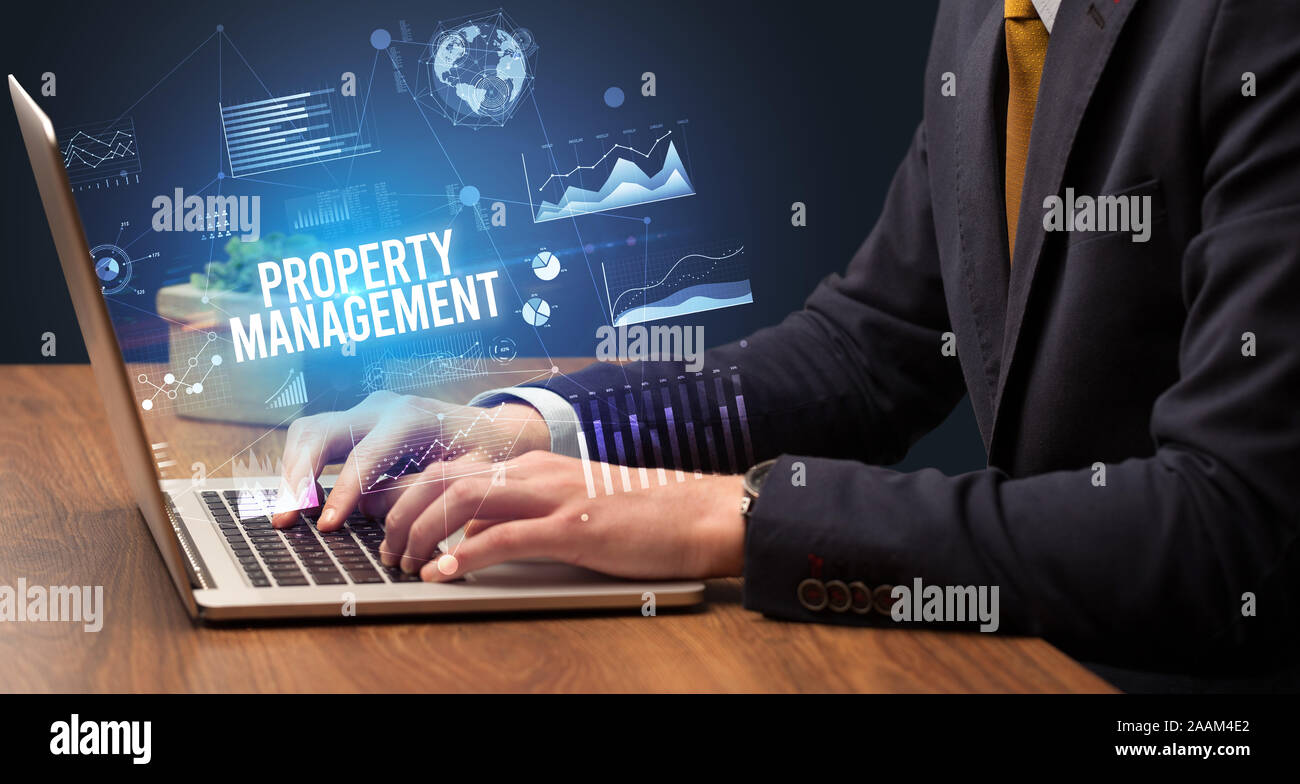 Businessman working on laptop avec inscription DE LA GESTION DES BIENS IMMOBILIERS, nouveau concept commercial Banque D'Images