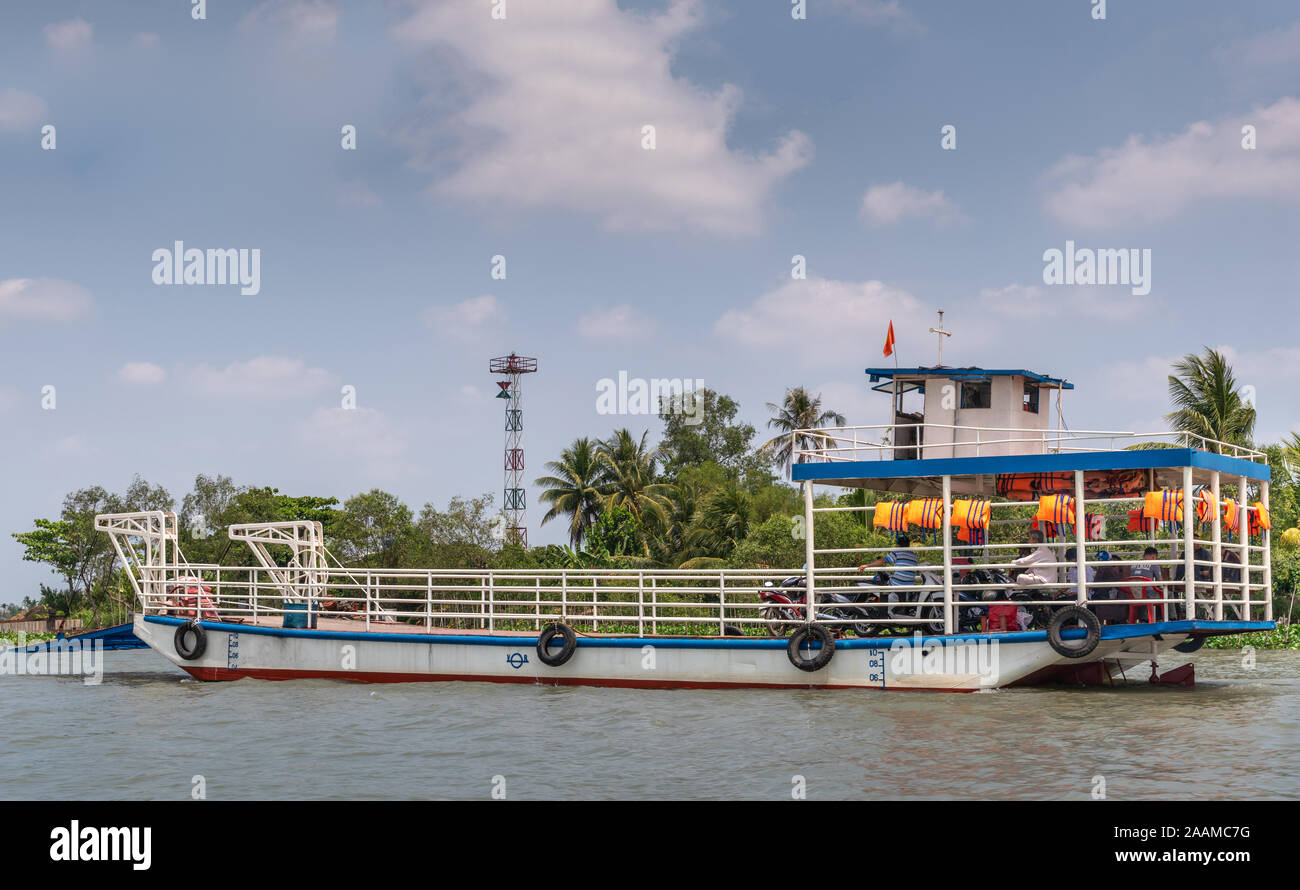 Tan Phong, Delta du Mekong, Vietnam - Mars 13, 2019 : Brun Mékong et un bleu-blanc standard ferry transportant les piétons et motos Banque D'Images