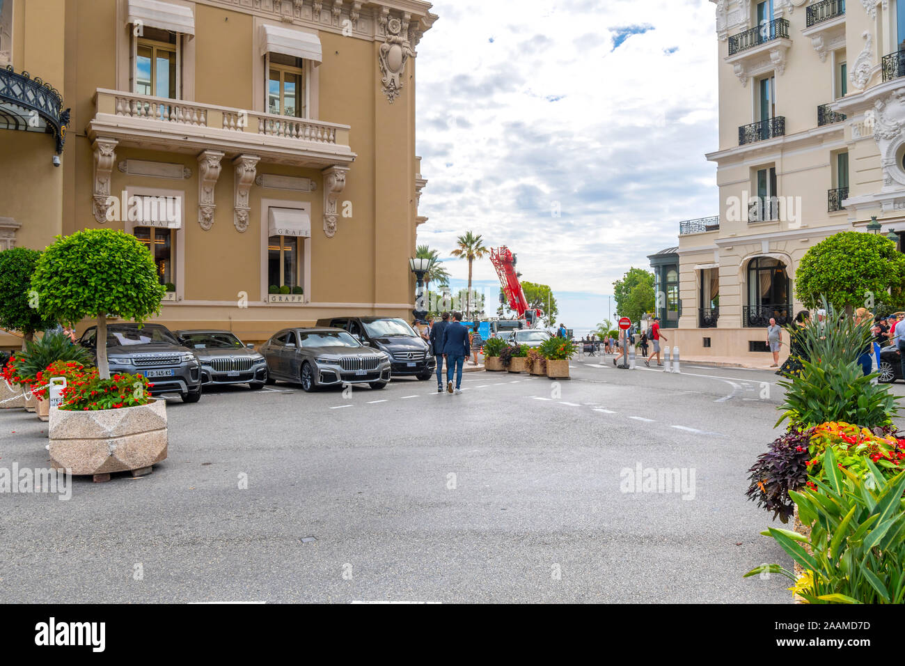 Deux hommes bien habillés quitter le parking du Casino de Monaco en route vers le port le long de la Côte d'Azur. Banque D'Images