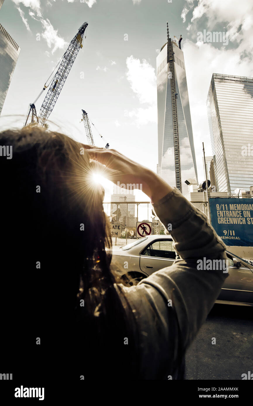 Jeune femme regarde le site de construction du One World Trade Center à New York, USA Banque D'Images
