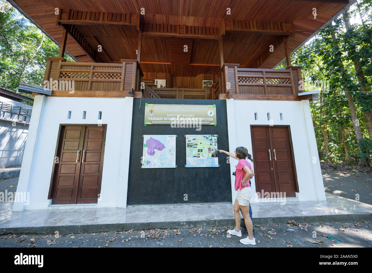 Visiteurs regardant la carte du parc national de Tangkoko au centre d'accueil, Sulawesi Indonésie. Banque D'Images