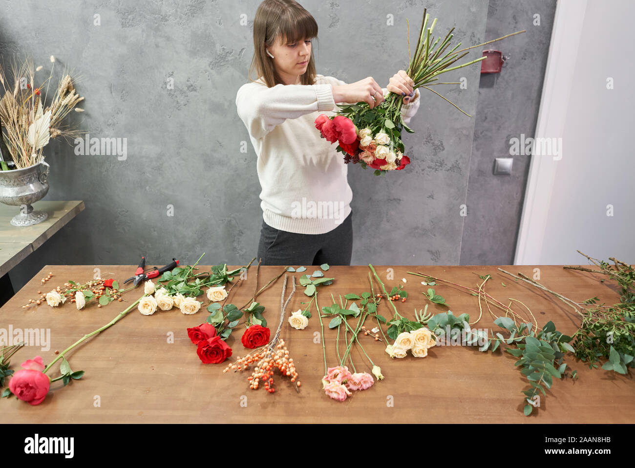 European shop concept. Femme fleuriste crée belle rouge bouquet de fleurs. Beau bouquet frais. L'éducation, master class et Banque D'Images