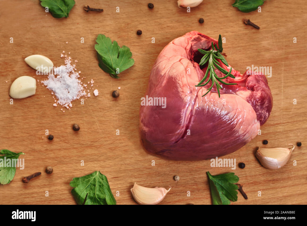 La viande crue, avec coeur de boeuf assaisonnements sur fond de bois Banque D'Images