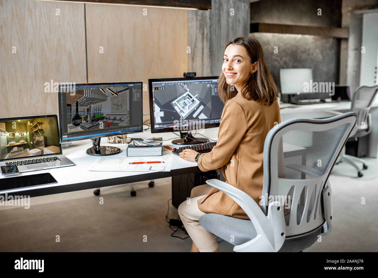 Portrait d'une jeune employée faisant office de création d'intérieur, la modélisation 3D sur l'ordinateur lors de l'assise à la société d'architecture de bureau moderne Banque D'Images