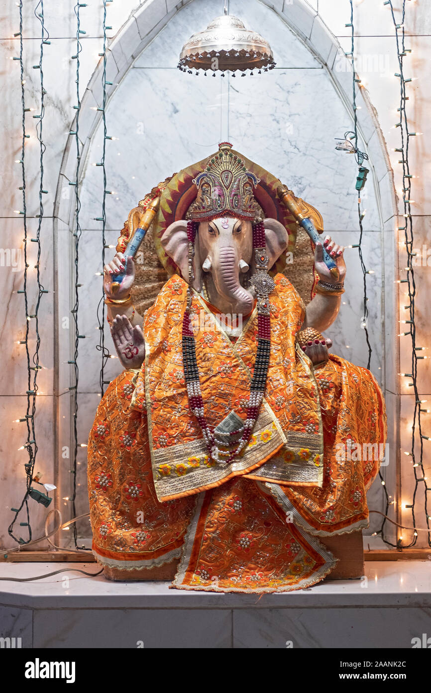 Une statue du dieu hindou Ganesh vêtus de robes orange au Satya Narayan Mandir à Queens, New York. Banque D'Images