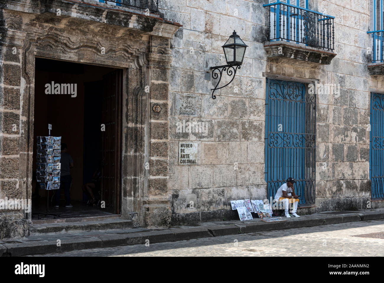 Un artiste de rue exposant ses œuvres pour la vente aux touristes devant le Museo de Arte Colonial sur la Plaza de la Catedral dans la vieille ville de la Havane, (Haba Banque D'Images