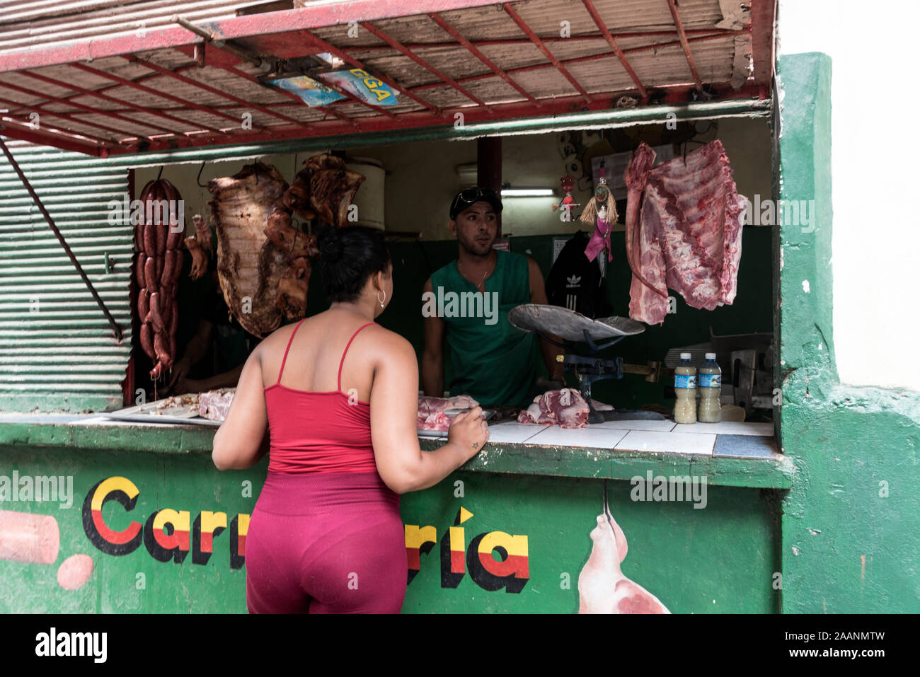 Un résident à une vitrine de boucherie avec une petite file d'attente à un fruit & Vegg au coin de la rue dans la vieille ville de la Havane à Cuba. Le gouvernement cubain est al Banque D'Images
