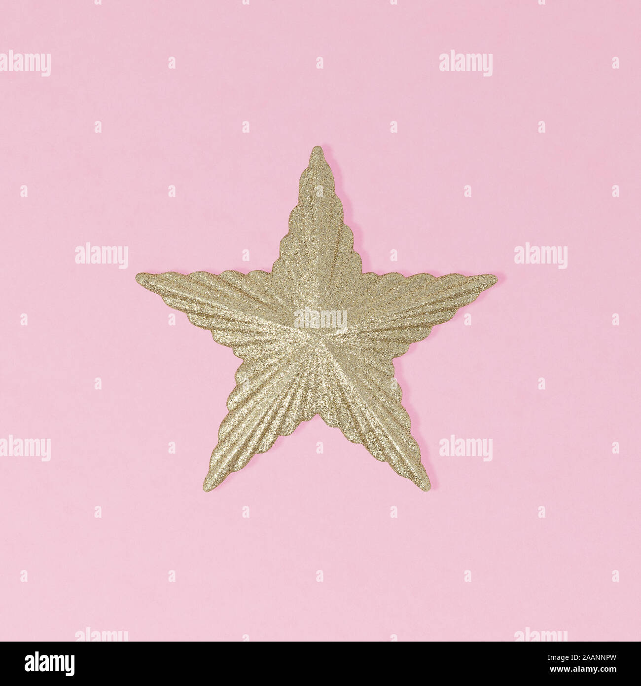 Étoile scintillante or isolé sur un fond rose, un minimum de notion de Noël Banque D'Images