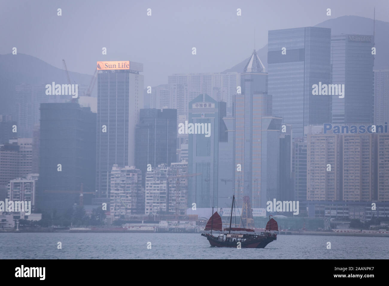 Un traditionnel, ancien bateau à voile avec les hauts immeubles de Hong Kong dans l'arrière-plan Banque D'Images