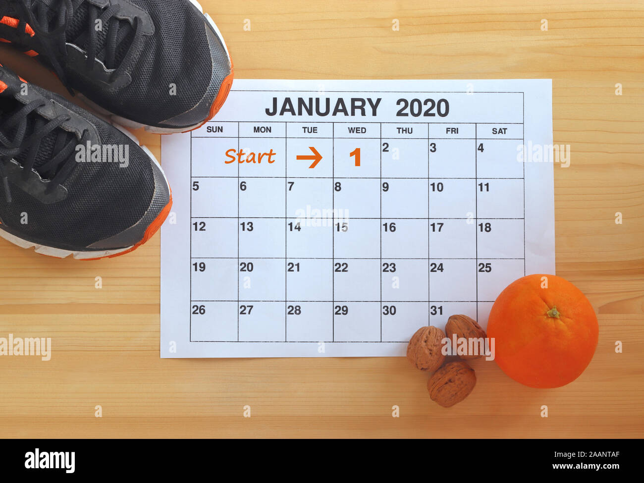 Janvier 2020 - Départ dans une nouvelle vie en bonne santé, la page Calendrier de janvier, de jogging, une orange et les noix sur une table en bois clair Banque D'Images