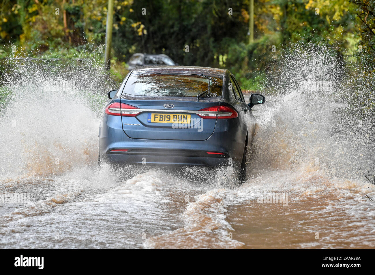 Une voiture conduit par l'eau de l'inondation après écoulement de l'eau entourant les champs Clyst St Mary, Exeter, et les routes inondées après de fortes pluies. Banque D'Images