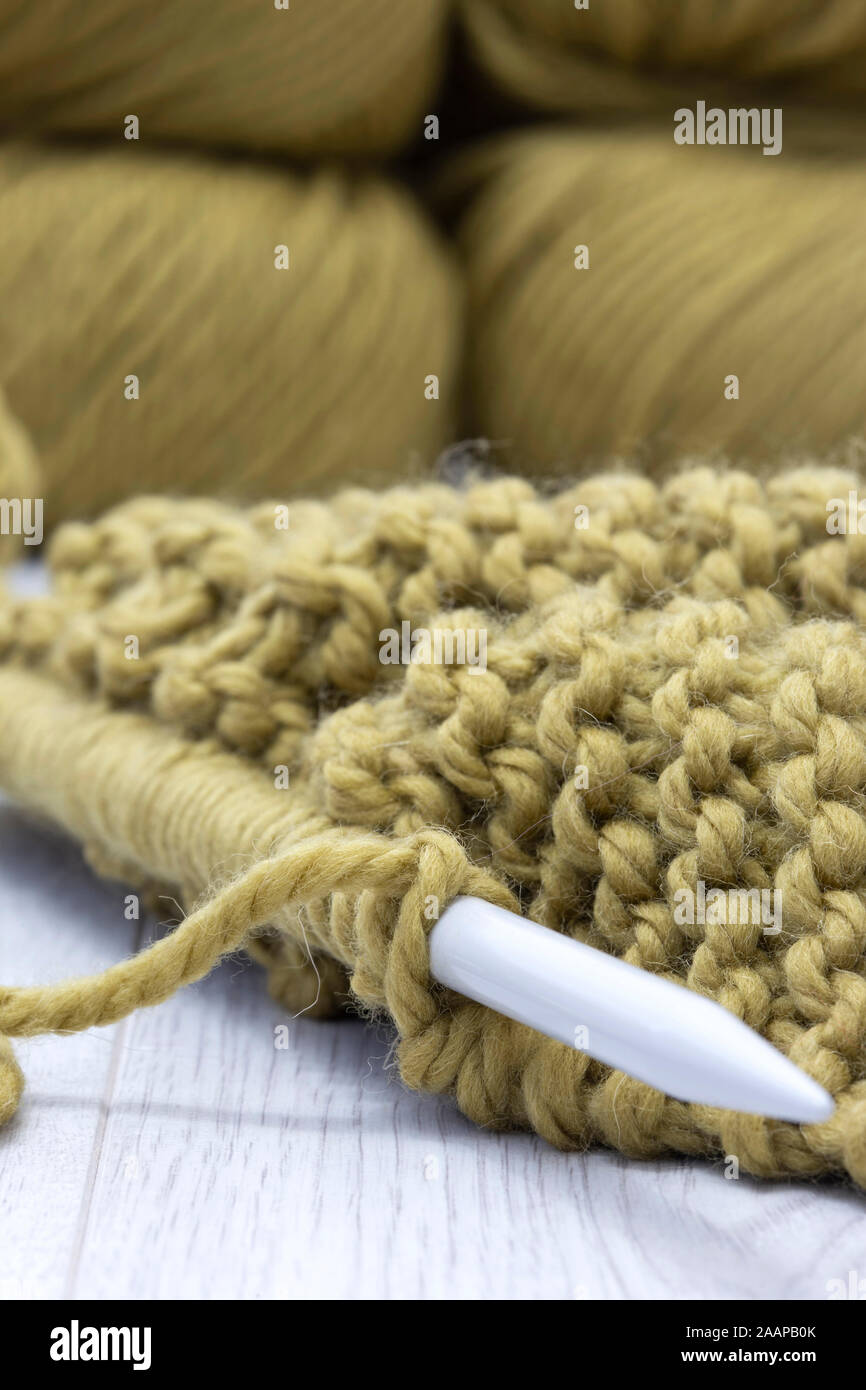 Cavalier de tricot avec un fil en pure laine mérinos tricot et avec une croix. Sur une surface en bois gris Banque D'Images