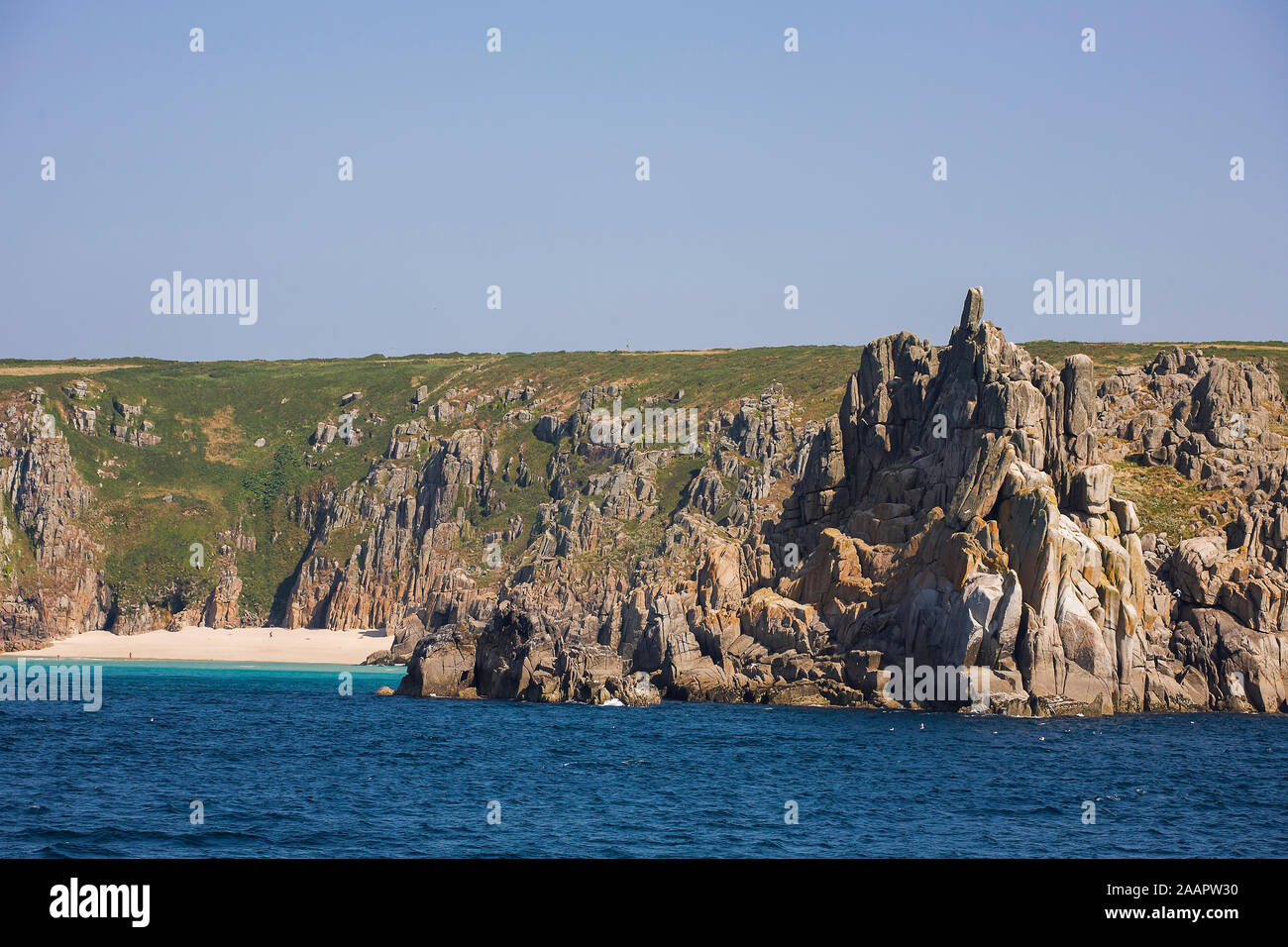Teryn Dinas et plage de Porthcurno, West Penwith, Cornwall, UK à partir de la mer sur une calme journée d'été Banque D'Images
