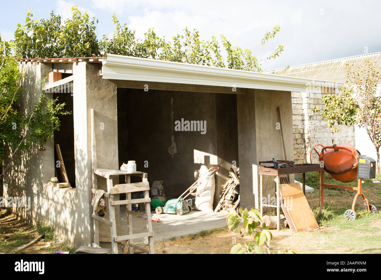 Bâtiment en béton non fini dans le jardin avec arbres fruitiers Banque D'Images