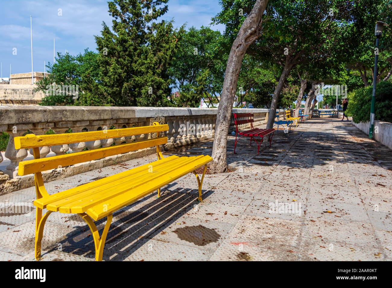 Banc de jardin public en jaune à Cospicua, Malte. Banque D'Images