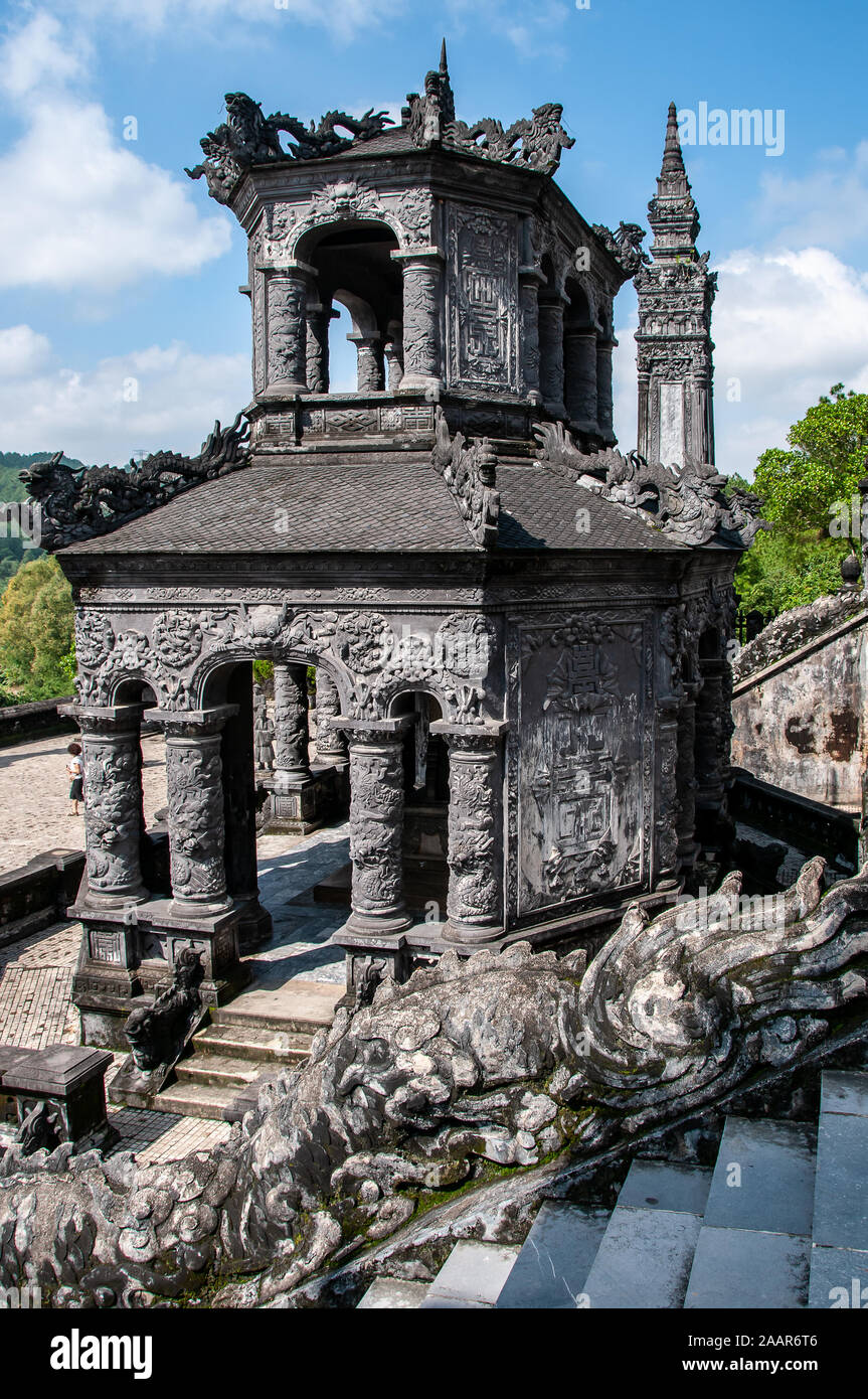 Des pavillons en pierre gris finement incrustés mènent à la somptueuse tombe de l'empereur Khai Dinh, près de Hué, au Vietnam Banque D'Images
