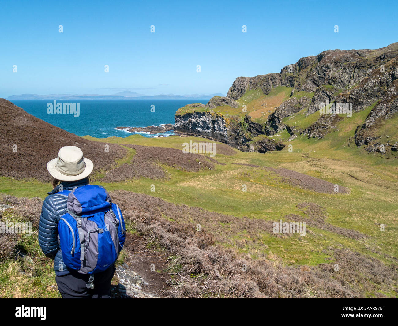 Les touristes à la recherche vers les falaises de la mer à Pig's Paradise,à l'île de Colonsay, Ecosse, Royaume-Uni Banque D'Images